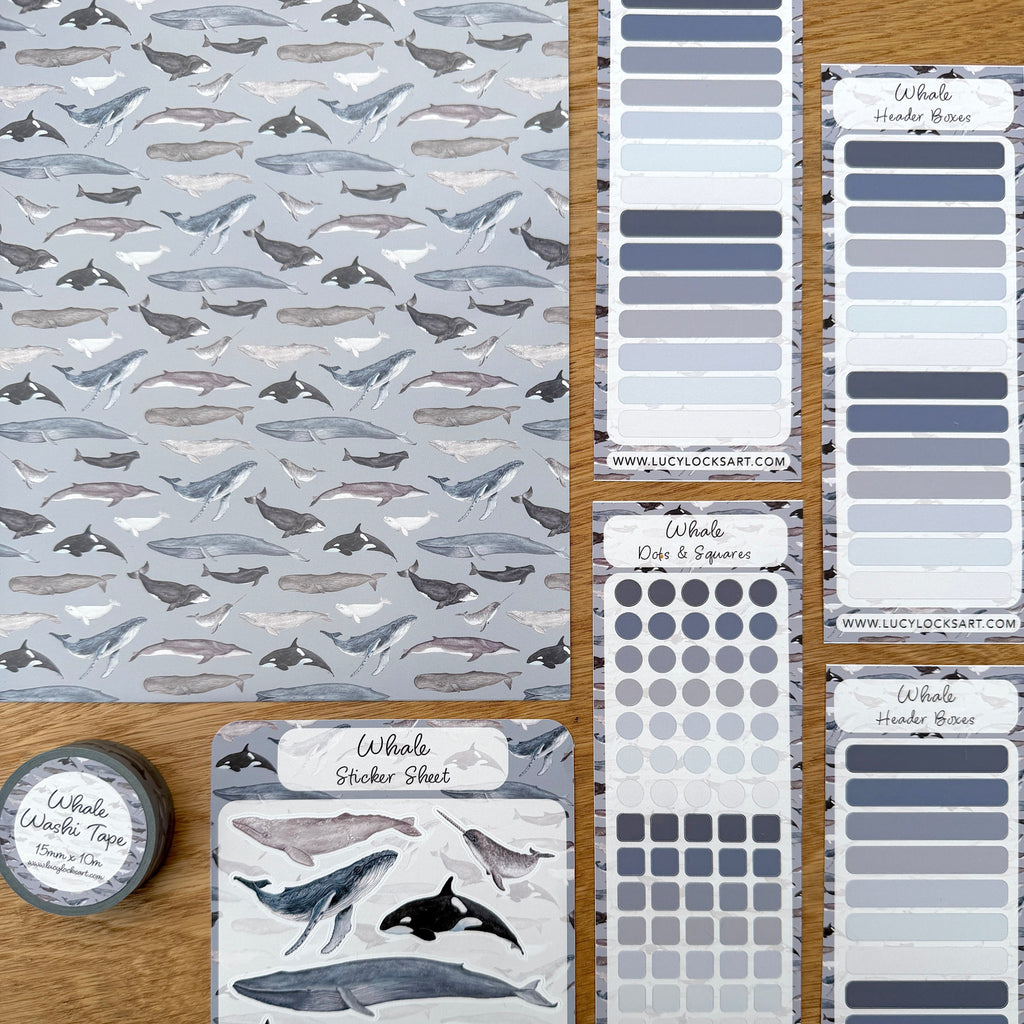 Collection of whale-themed journal supplies on a wooden surface