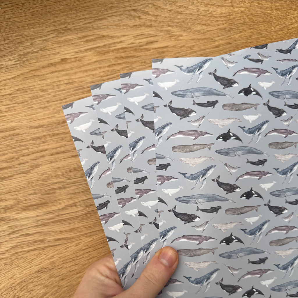 Hand holding a sheet of patterned paper with a wooden surface underneath